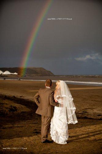 Rainbow shines on beach wedding in December