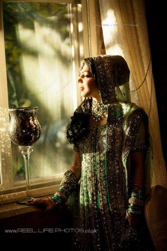 Magical sunlight on Asian bride's face by window